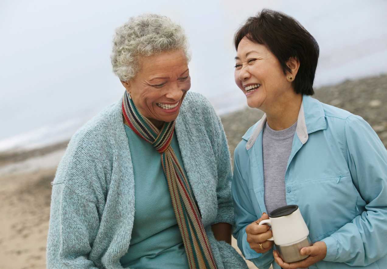 Two elderly women on a beach who are happy to have SSDI benefits.