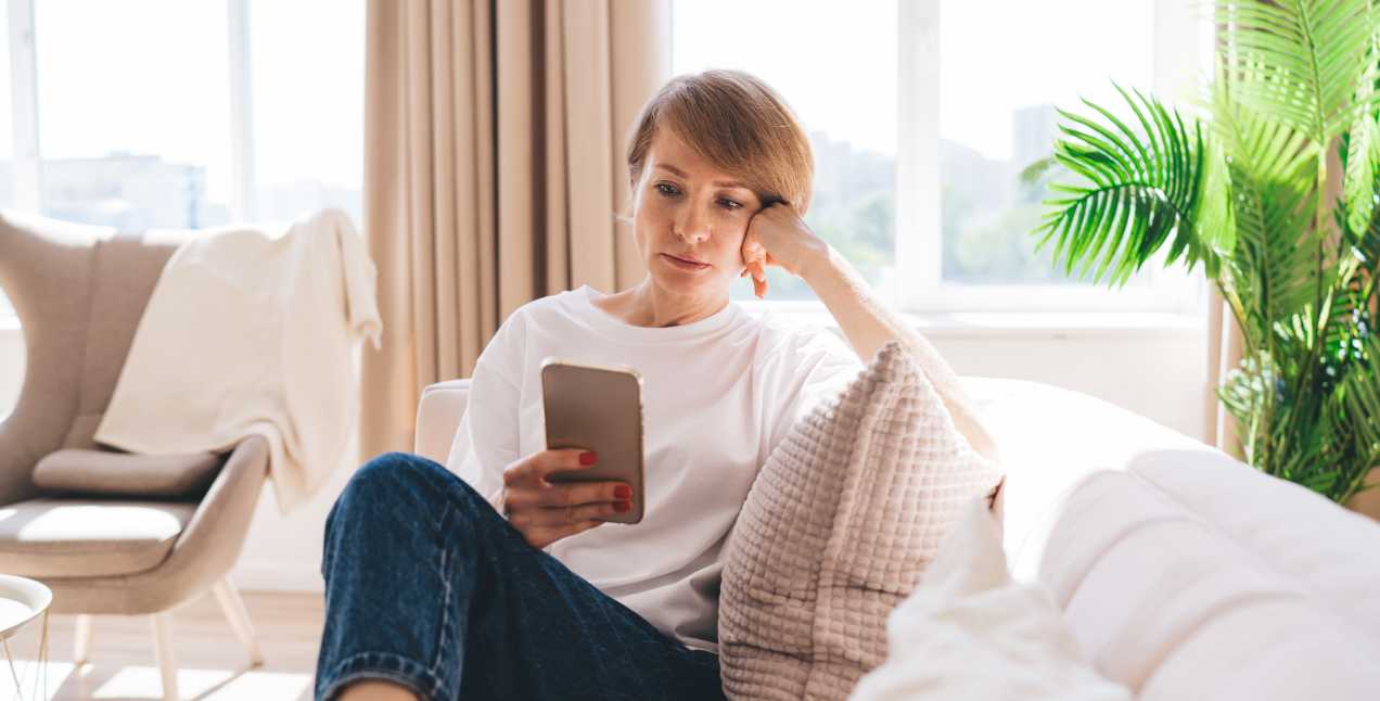 A woman, recently denied Social Security Disability, viewing her denied application on her cell phone.
