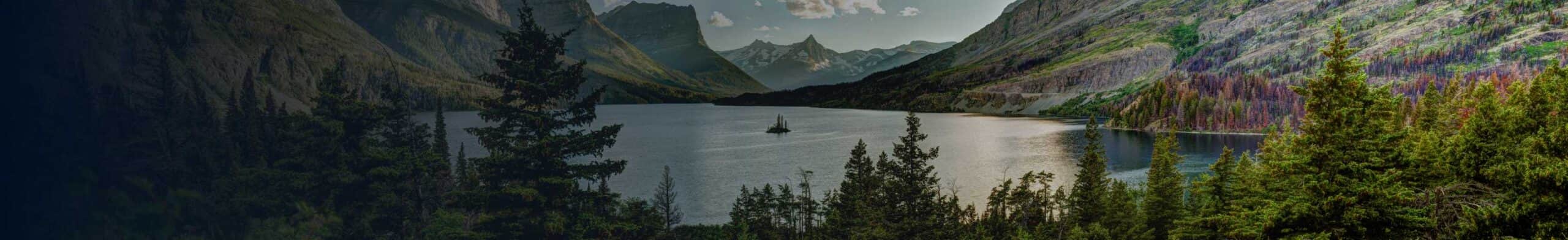 A lake surrounded by forest and mountains in montana