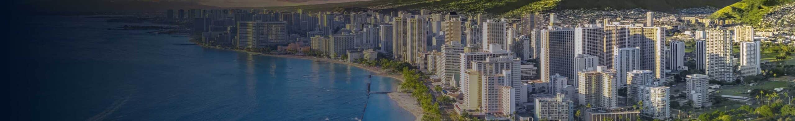 Honolulu, Hi as seen from the air with a section of ocean and beach in the foreground