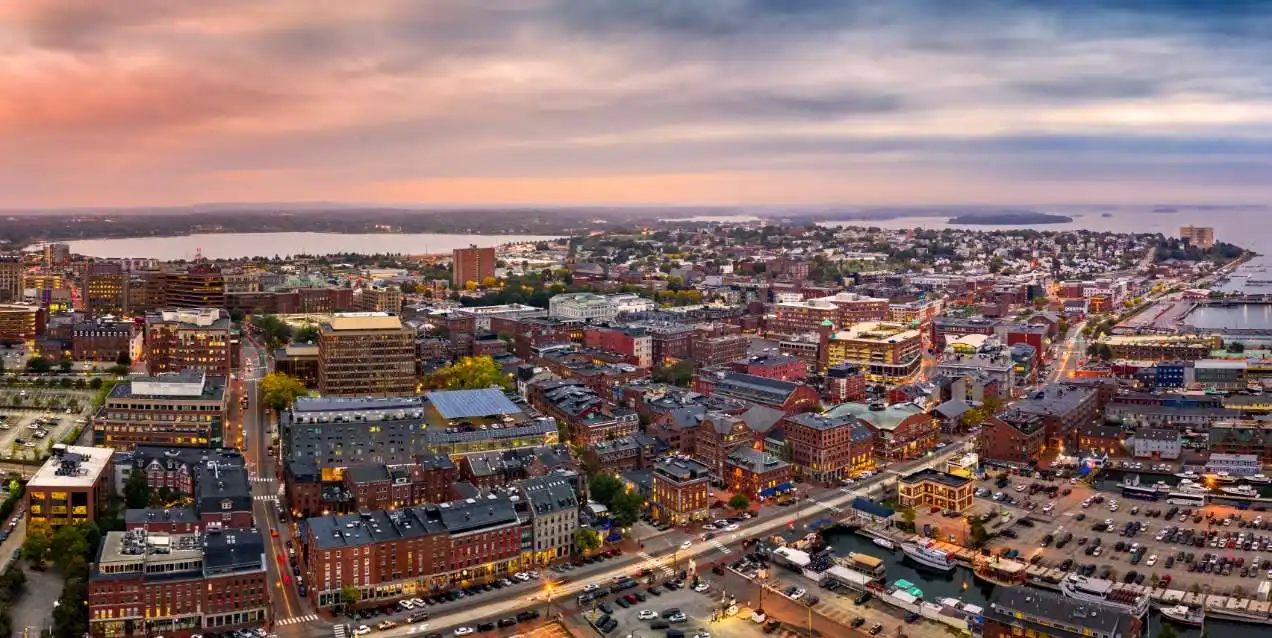 Aerial view of Portland, Maine's brick downtown and waterfront at dusk.